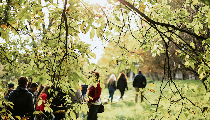 Menschen steht in der Natur beisammen – Symbol für Gemeinschaft und gegenseitige Unterstützung